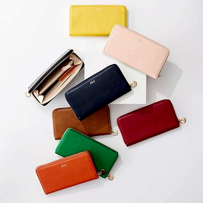 Pile of colorful zip wallets emblazoned with monograms in gold are a perfect anniversary gift