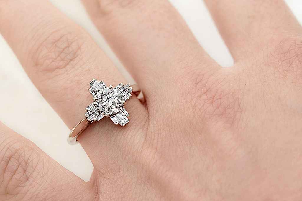 Close up shot of a hand wearing a fully custom gold and diamond engagement ring.