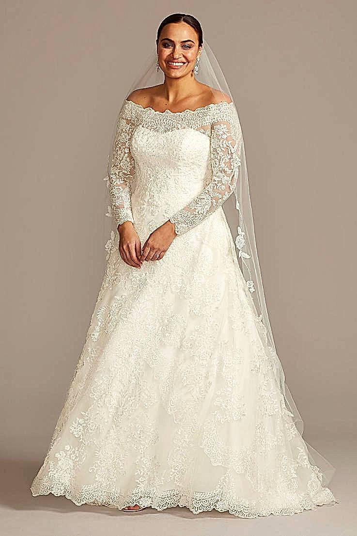 smiling woman wearing a veil and lace wedding dress