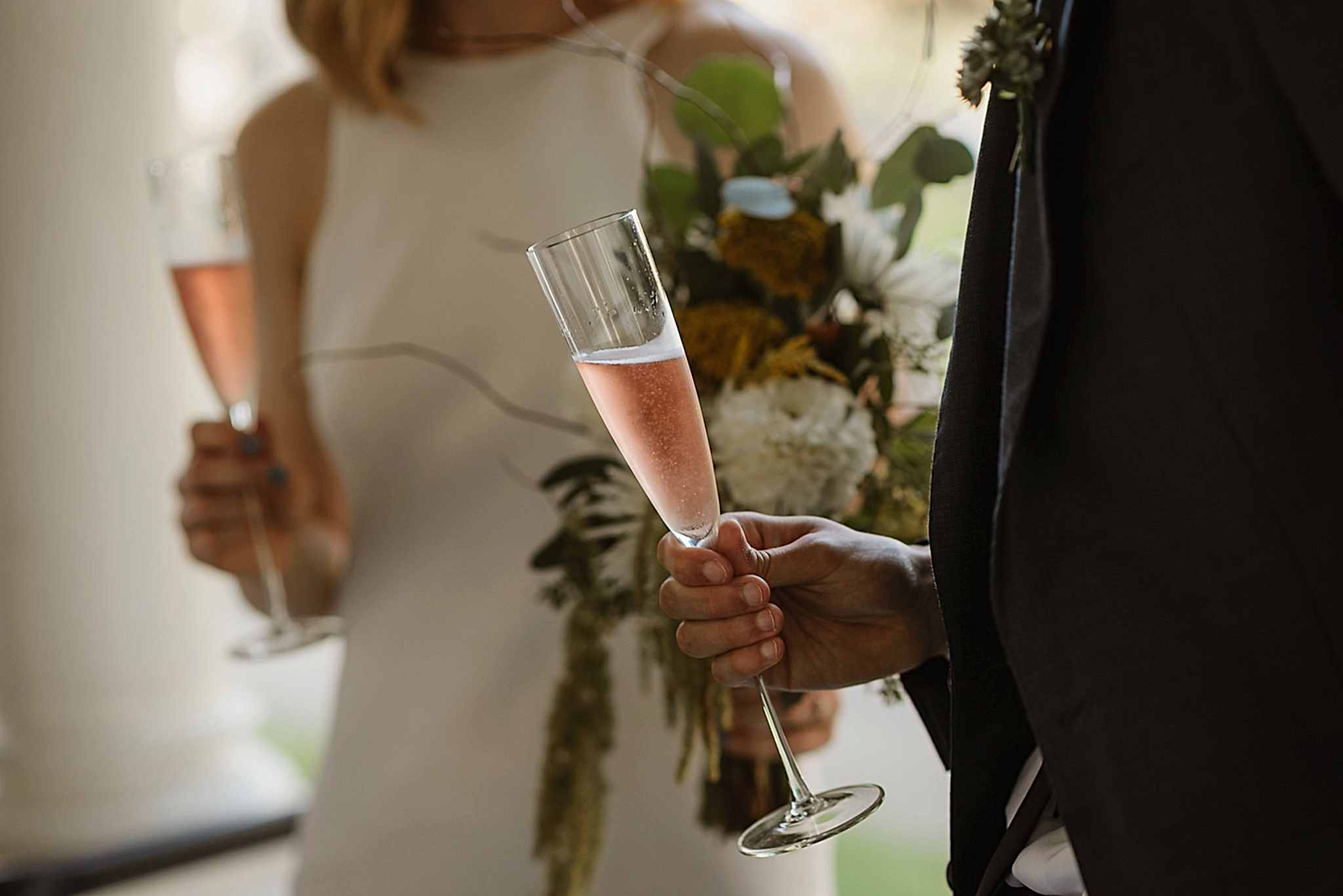 Wedding couple holding champagne flutes during wedding toasts
