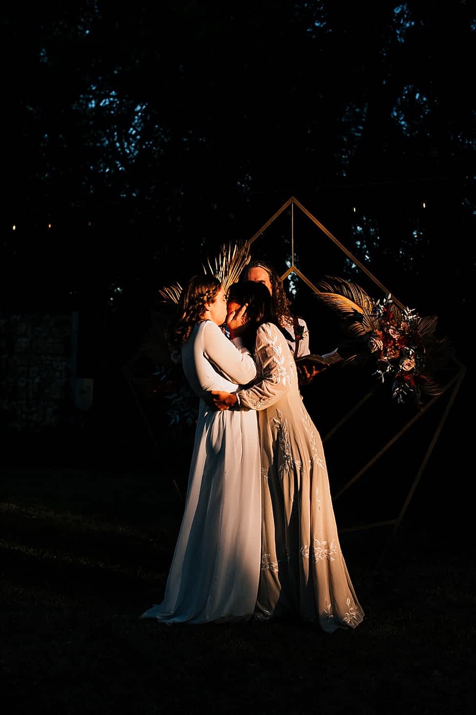 Two brides kissing at the end of their wedding ceremony